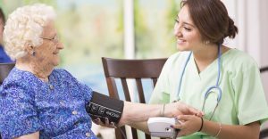 Home care provider supporting elderly person during hospital visit